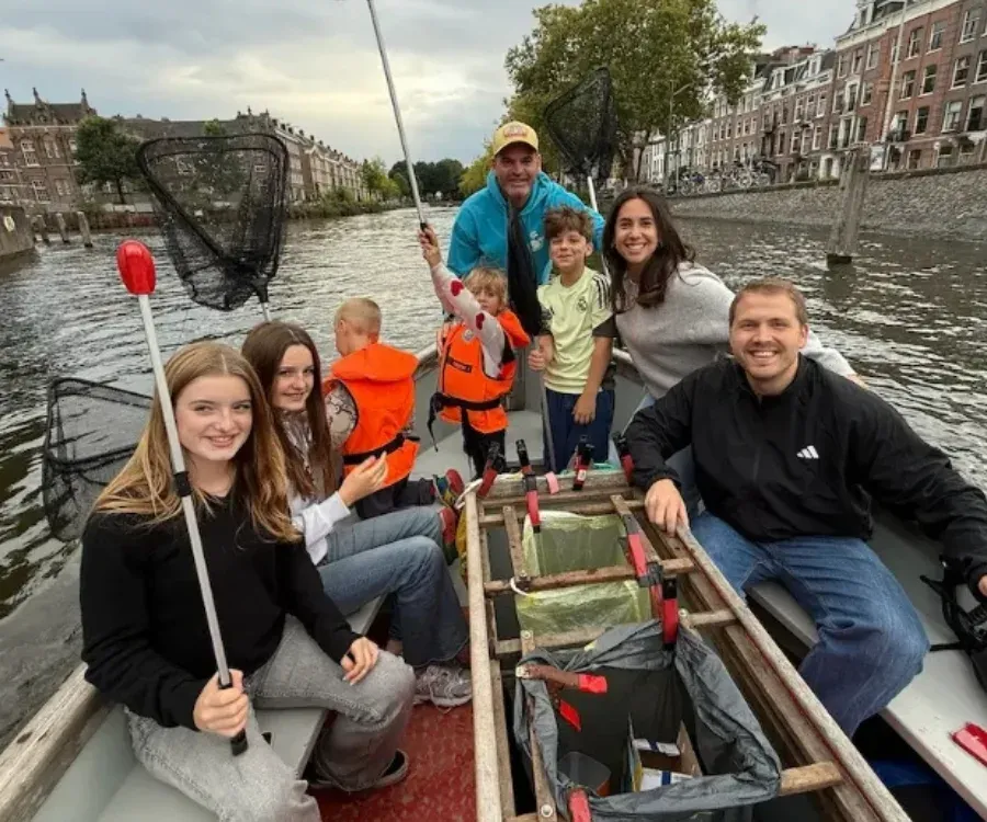 Donnies ruimen afval op vanaf een boot in Amsterdam